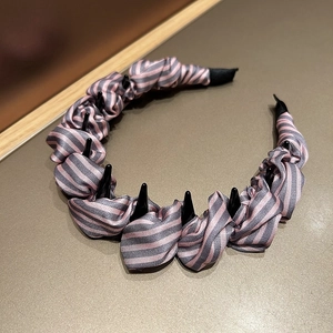 Dettaglio del cerchietto in raso a righe rosa e grigie con denti di fissaggio