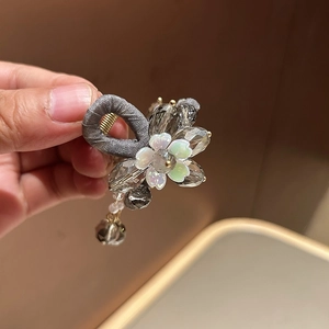 Détail de la pince à cheveux en tissu gris avec perles en cristal et pendentif perle