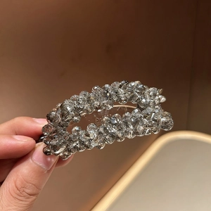 Elegant banana hair clip featuring shimmering grey and clear crystal beads in a curved design