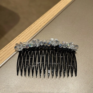 Detail shot of colorful crystal beads on a black hair comb with iridescent faceted finish