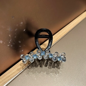 Macro detail of elegant hair claw clip featuring light blue and clear crystal beads