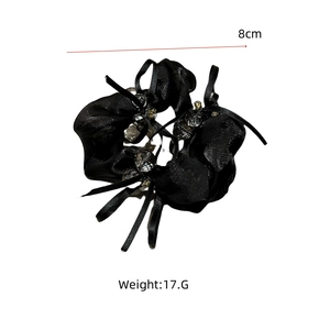 Detailansicht eines 8cm schwarzen Satin-Scrunchies mit Perlen, Bändern und 17g Gewicht