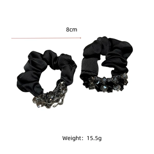 Close-up of black satin scrunchies with crystal beads measuring 8cm in diameter