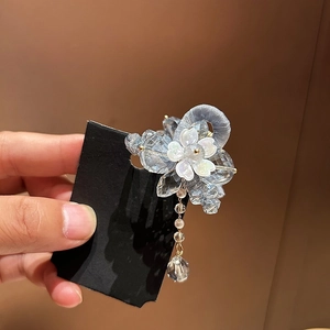 Détail de la pince à cheveux fleur en cristal avec perles bleues et long pompon