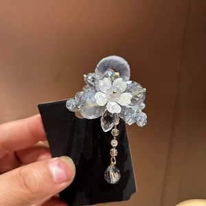 Vue détaillée d'une pince à cheveux florale bleu clair avec perles et longs glands