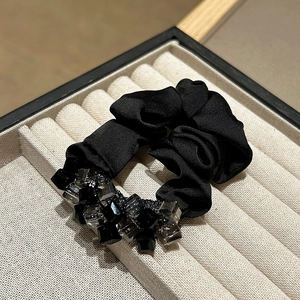 Detailed view of premium black satin scrunchie decorated with sparkling square crystal beads