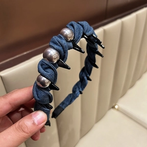 Close-up of denim headband with silver beads and internal comb teeth for hair styling
