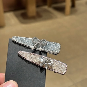 Close-up of sparkling duckbill clips with rhinestones, butterfly bows and pearls