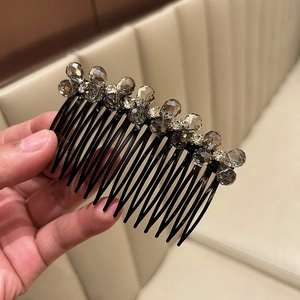 Detail of crystal hair comb showing dark grey beads and white rhinestones for styling