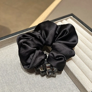 Elegant black satin scrunchie with crystal stones displayed in a premium jewelry box