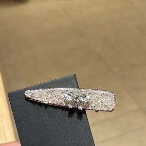 Blue bow duckbill clip with silver rhinestones on a display card for women