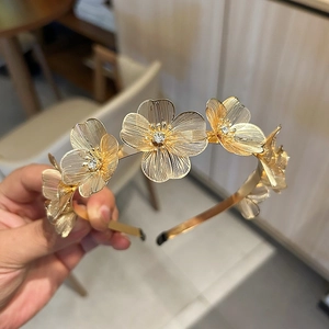 Elegant gold metal headband with five rhinestone flowers and textured ginkgo leaves style