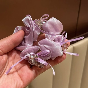 Detailaufnahme von lavendelfarbenem Satin-Haargummi mit Kristallperlen und Schleifen