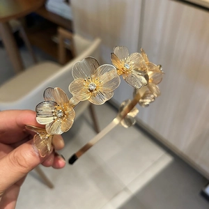 Elegant gold flower headband with intricate ginkgo leaf metalwork and shiny rhinestones