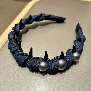 Detail of dark blue denim headband featuring punk style black studs and grey pearls