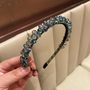 Macro view showing handcrafted crystal bead weaving on a dark luxury headband