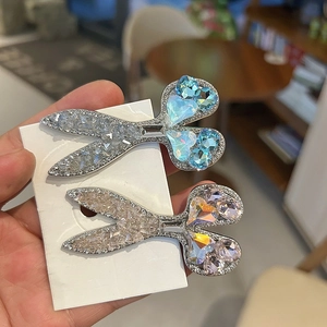 Close-up of heart-shaped blue rhinestone scissor hair clips with sparkling crystals