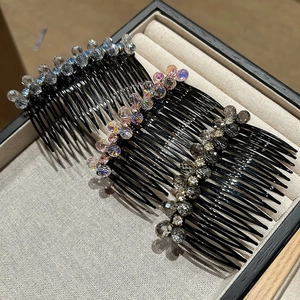 Detail of three crystal-studded hair side combs in blue, pink, and smoky grey tones