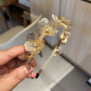 Golden metal flower headband with ginkgo leaf design and sparkling rhinestones