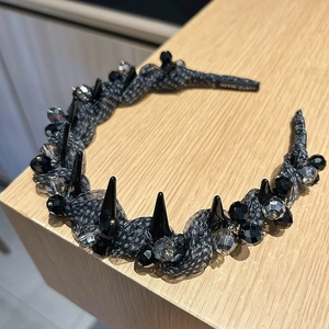 Détail d'un serre-tête punk fait main avec résille noire, clous et cristaux