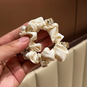 Elegant satin scrunchie in cream white with decorative pearls and faceted clear beads