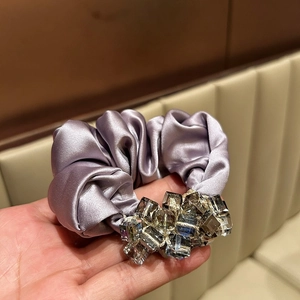 Detail of lavender satin scrunchie with grey crystal beads and silk texture