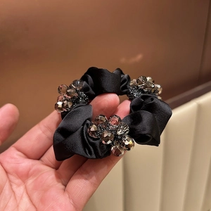 Detail of black satin scrunchie with sparkling grey crystal bead embellishments