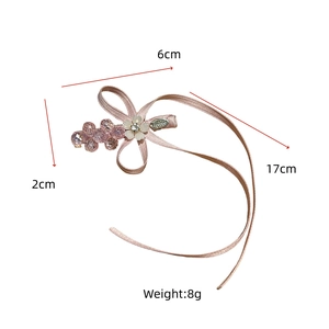 Vue détaillée de la pince à cheveux avec nœud rose, perles et longs rubans
