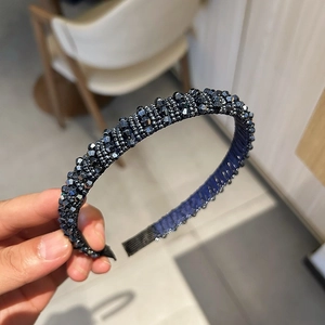 Détail du serre-tête en perles de cristal gris foncé avec une texture éclatante et chic