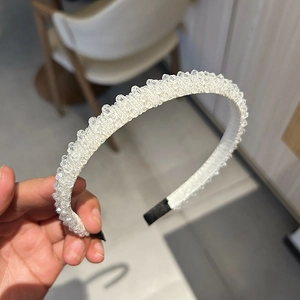 Vue détaillée d'un serre-tête artisanal avec perles de cristal blanc et embouts de protection