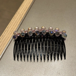 Detailed close-up of a 14-tooth hair comb with pink and purple crystal bead accents