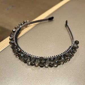 Detail view of gray faceted crystal beads intricately wrapped on a black headband