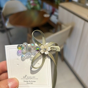 Barrette à cheveux avec nœud en ruban vert olive et cristaux colorés sur carte bijou