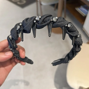 Dettaglio del cerchietto fatto a mano in tessuto nero con strass e punte punk in metallo