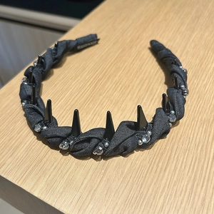 Dettaglio cerchietto fatto a mano in tessuto nero con borchie punk e strass brillanti