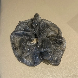 Close-up of a dark grey oversized scrunchie with sparkling fabric and delicate white pearls