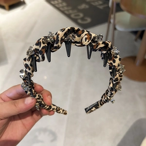 Detail of leopard print headband with black cone studs and sparkling rhinestones