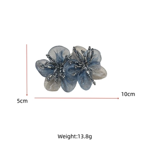 Detail of 10cm handmade organza flower hair clip with blue petals and bead center