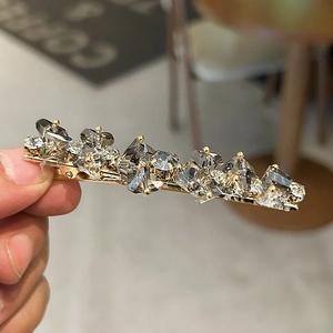 Makroaufnahme einer Vintage-Haarklammer mit grauen Kristallen und goldener Basis