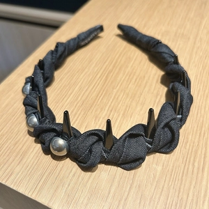 Détail du serre-tête en denim noir avec perles argentées et pointes style punk