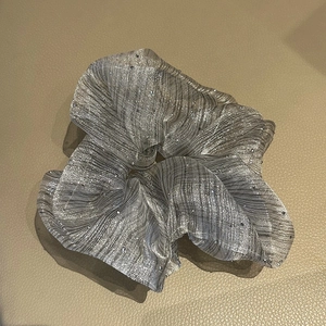 Detail of silver grey seersucker scrunchie with rhinestones and metallic stripe texture