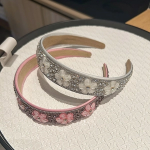 Gros plan détaillé des serre-têtes en cristal rose et blanc avec motifs de fleurs