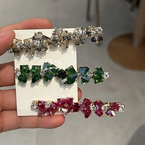 Detailansicht von drei Vintage-Kristallhaarklammern in Smaragd, Rubin und Klarglas