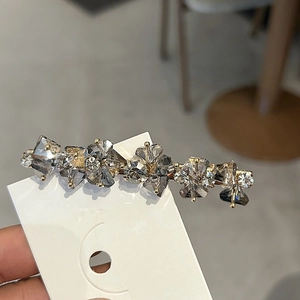 Eleganter Kristall-Blumen-Haarclip mit grauen und klaren Steinen auf Gold-Metallbasis