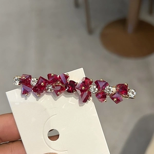 Eleganter goldener Haarclip mit funkelnden roten und weißen Kristallen im geometrischen Design