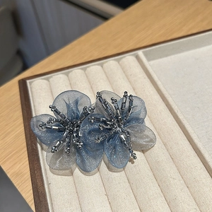 Detailed macro view of handmade organza double flower hair clip with crystal beads