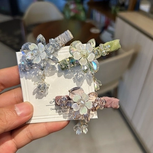 Detailed close-up of floral crystal hair clips set with dangling pendants and s925 silver