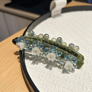 Pince banane élégante avec tissu vert, strass bleus et motifs de muguet pour les cheveux