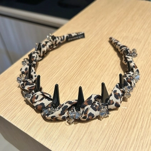 Close-up of leopard print headband with black spikes and clear crystal embellishments