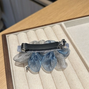 Detailed back view of the blue organza flower hair clip showing the secure metal spring clasp